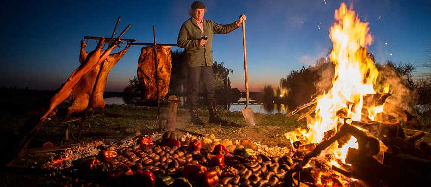 Chef Francis Mallmann at Siete Fuegos, Photo Courtesy The Vines of Mendoza. Chef Francis Mallmann tends the fires at Siete Fuegos restaurant in Mendoza, Argentina