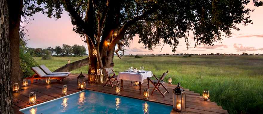 Dining on the pool deck at Duba Plains Camp in the Okavango Delta, Botswana. Photo Courtesy Great Plains Conservation Guest private dining on the pool deck at Duba Plains Camp in the Okavango Delta, Botswana