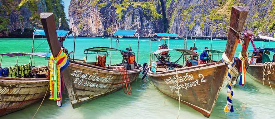 Phi Phi island in Thailand Wooden boats in the turquoise waters of Maya Bay with limestone karst cliffs on Phi Phi island in Thailand