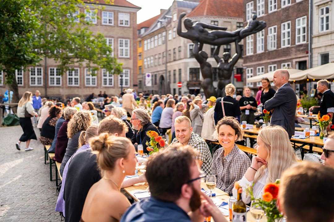 Outdoor dining scene at Copenhagen Cooking and Food Festival, people enjoying food in a lively square.