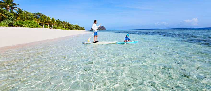 Fiji Vacation for Families Father and son stand up paddle boarding in Fiji