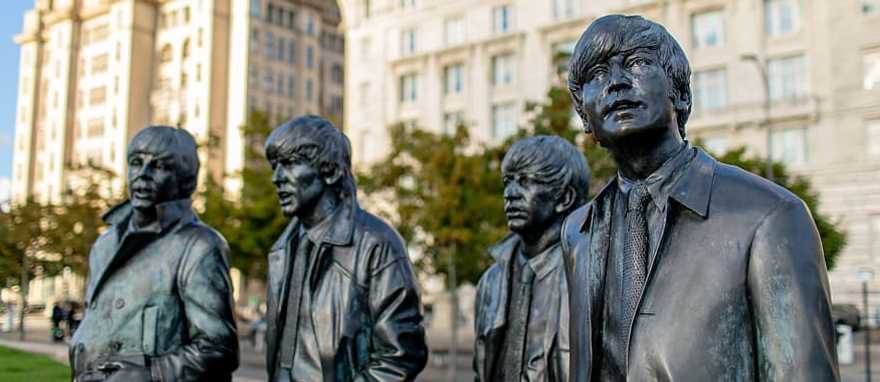 Lifelike bronze statues of The Beatles on Liverpool’s waterfront promenade.