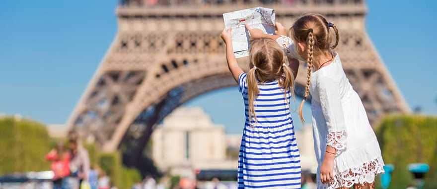 Paris, france Little girls with a map of Paris on the background of the Eiffel tower, Paris