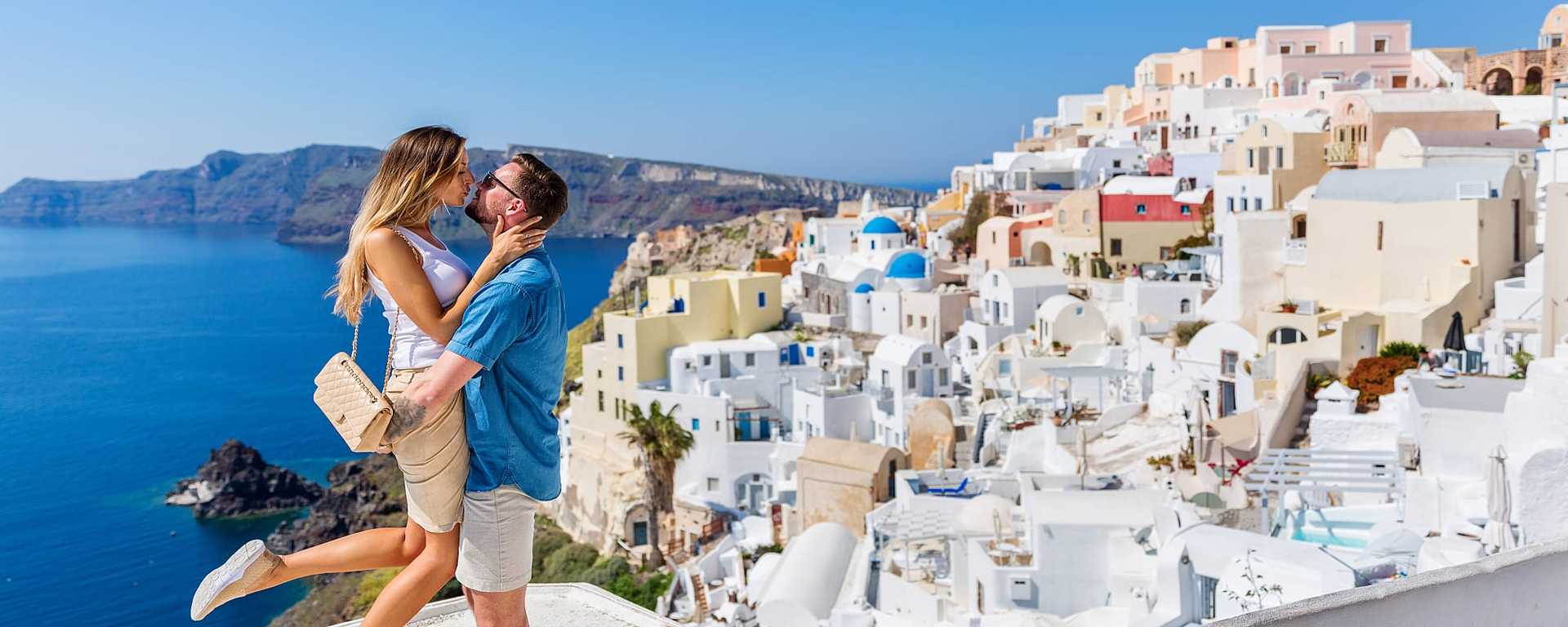 Couple kissing on rooftop overlooking the caldera Santorini, Greece