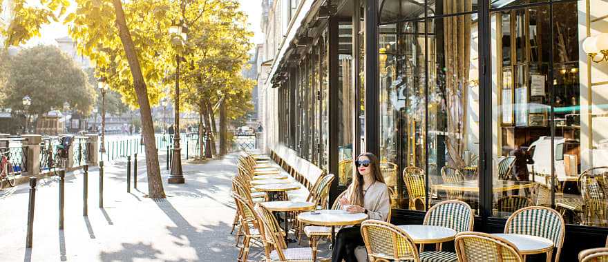 Woman sitting at an outdoor cafe in Paris, France update is here