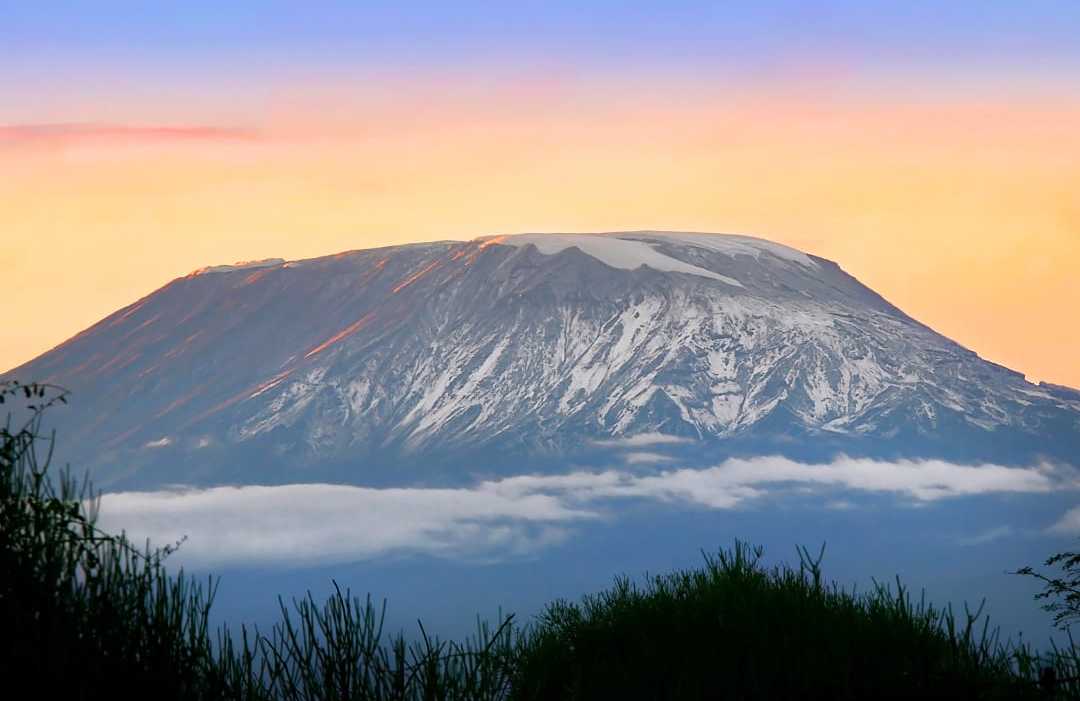 Mount Kilimanjaro’s Kibo peak glowing under the light of dawn.