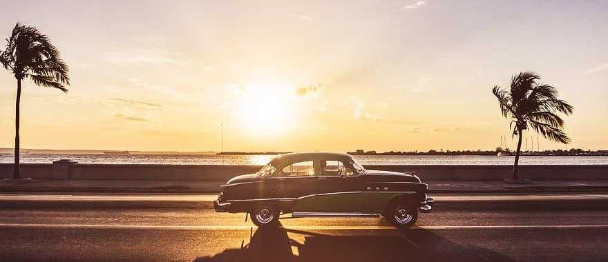 Classic car driving along the Malecon in Havana, Cuba.