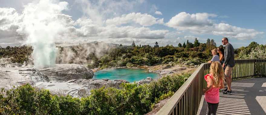 Te Puia in Rotorua, New Zealand. Photo courtesy of Destination Rotorua Family viewing the geothermal lake and geyser at Te Puia in Rotorua, New Zealand