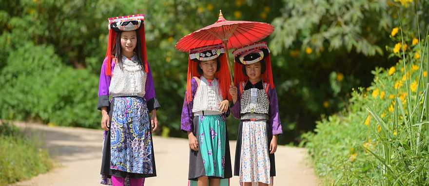 Three young Lahu Tribe girls in custom dress, smiling among the sunlight in Thailand. Three young Lahu Tribe girls in custom dress, smiling among the sunlight in Thailand.