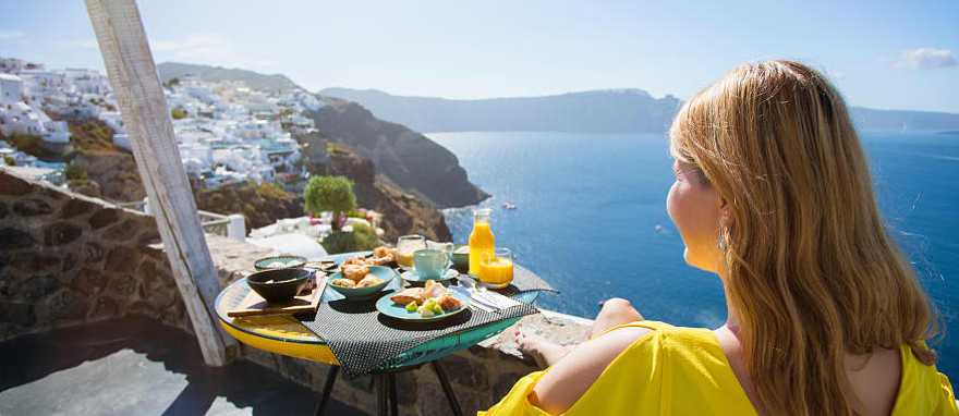 Santorini, Greece Traveler enjoying the view from private terrace in Santorini