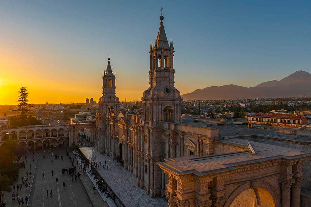 Arequipa Cathedral at sunset, historic landmark in Peru with volcanic mountains in the background