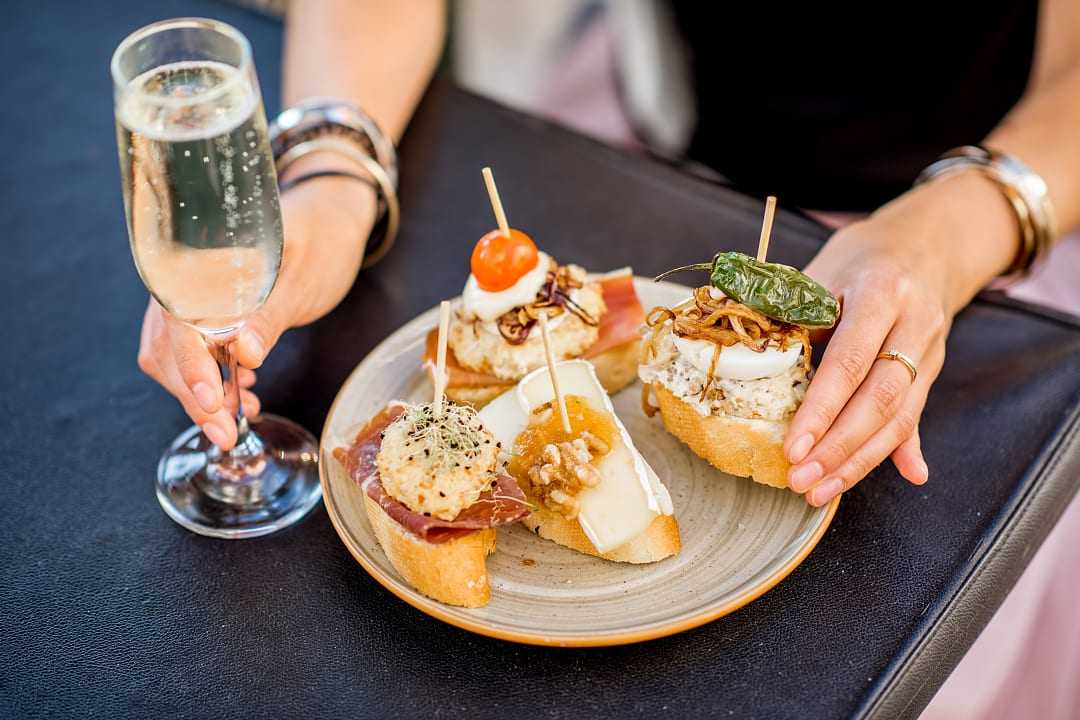 Plate of traditional Spanish pintxos with a glass of cava in San Sebastián, Spain