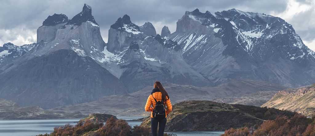 Torres del Paine National Park in Patagonia, Chile Hiker walking toward Torres del Paine peaks in Patagonia, Chile.