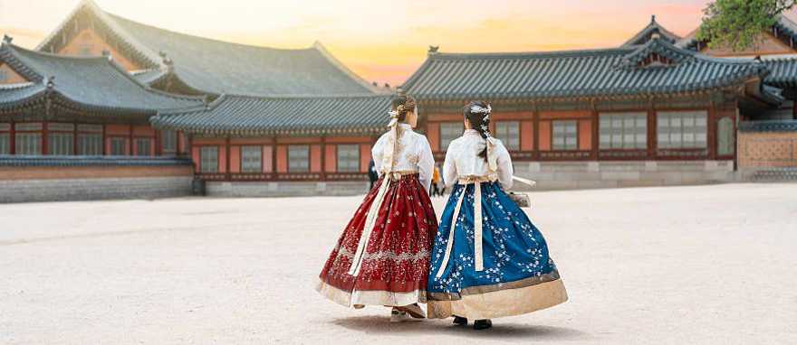 Women in hanbok stroll through the traditional-style homes in Seoul’s village.