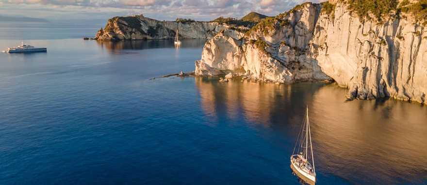 Sailboats at sunset around the beautiful island of Ponza in Italy