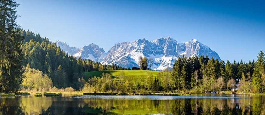 Idyllic alpine scenery, snowy mountains mirroring in a small lake in Tyrol, Austria. Idyllic alpine scenery, snowy mountains mirroring in a small lake in Tyrol, Austria.