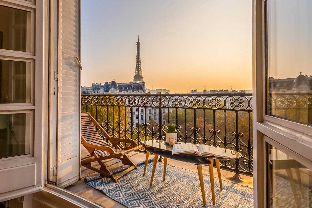 Stunning view of the Eiffel Tower at sunset, from a Parisian balcony.