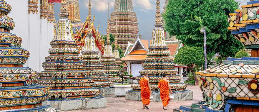 Wat Pho Temple in Bangkok, Thailand Two monks in colorful orange robes walking through Wat Pho Temple in Bangkok, Thailand