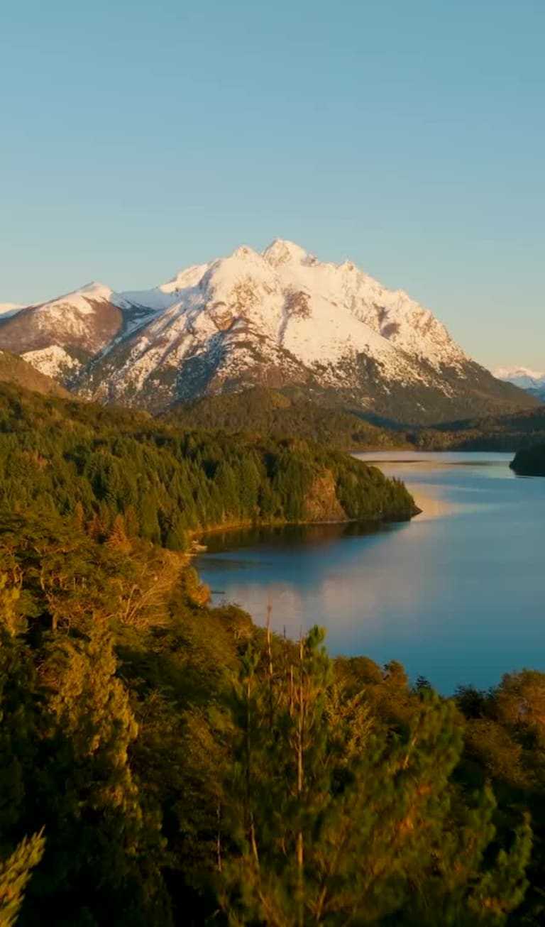 Scenic landscape of a mountain lake in Bariloche, Patagonia, Argentina, with snow-capped peaks and forests